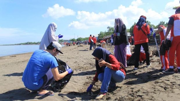 Para remaja di Makassar bersih-bersih sampah di pantai.