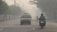 Warga melintas di jalan yang berkabut asap pekat dari kebakaran hutan dan lahan (karhutla) di kota Dumai, Dumai. Riau, Sabtu (23/2/2019). ANTARA FOTO/Aswaddy Hamid.