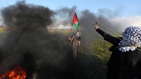 Pemuda Palestina melepaskan ketapel ke arah polisi Israel. REUTERS/Ibraheem Abu Mustafa.