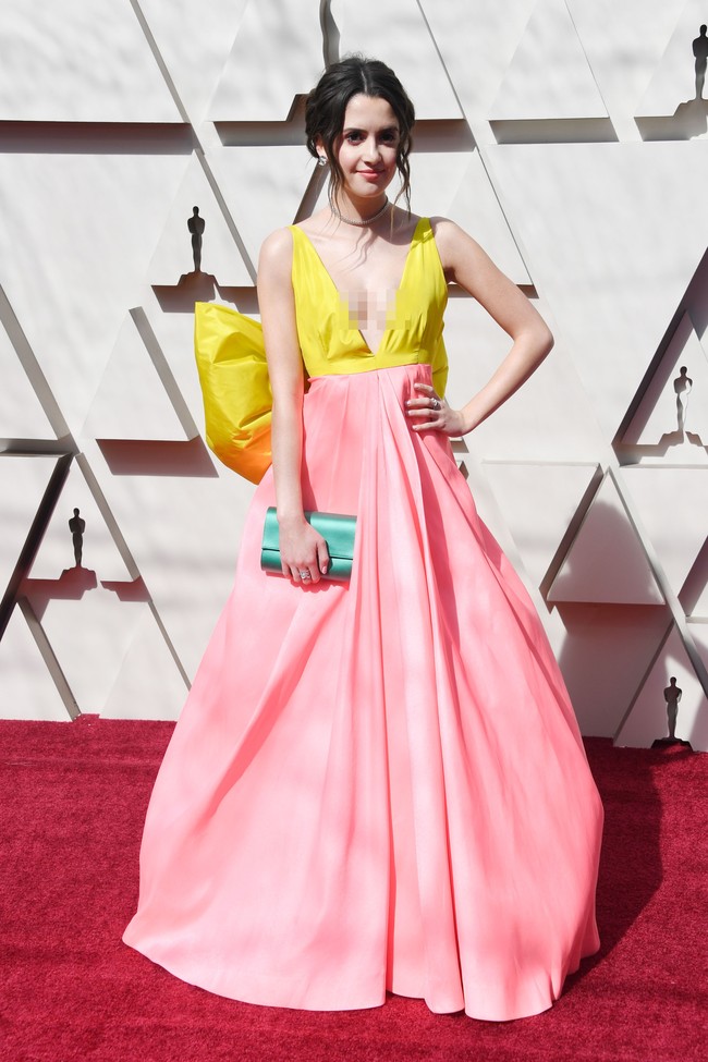 Mantan aktris Disney Laura Marano mencuri atensi dengan gaun neon berbeda warna. Belum lagi aksen pita besar di belakang pinggangnya terlihat berlebihan. Foto: Frazer Harrison/Getty Images