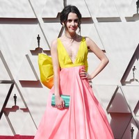 Mantan aktris Disney Laura Marano mencuri atensi dengan gaun neon berbeda warna. Belum lagi aksen pita besar di belakang pinggangnya terlihat berlebihan. Foto: Frazer Harrison/Getty Images