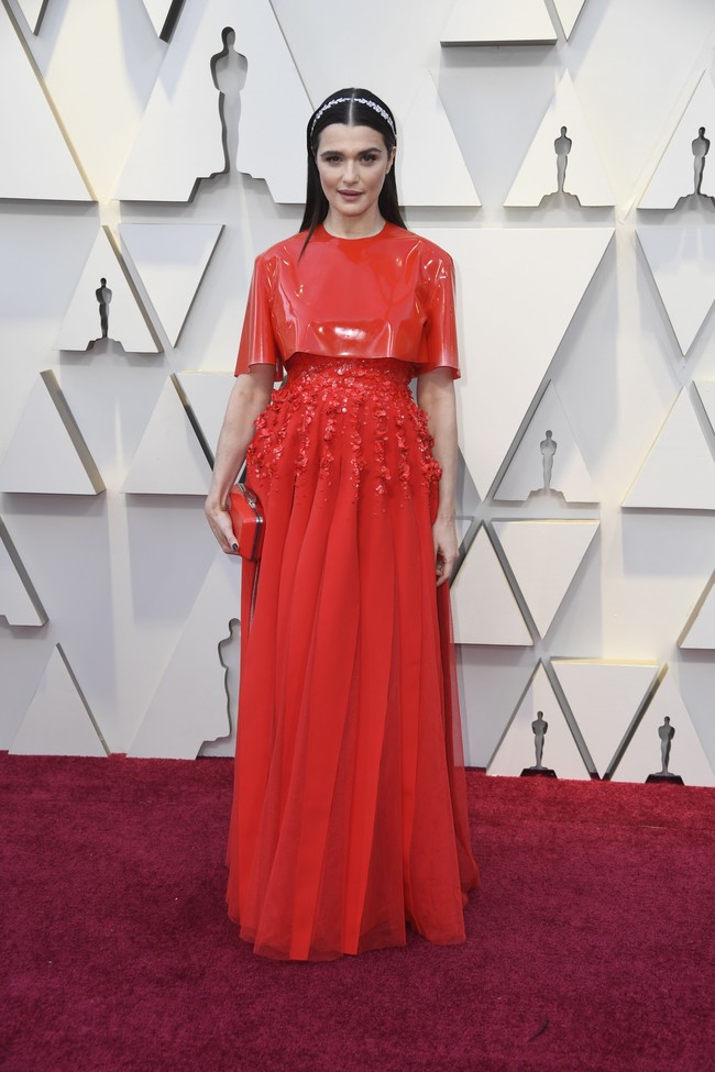 Rachel Weisz hadir di Oscars 2019, di Dolby Theatre, Los Angeles berbalut gaun merah dengan paduan dua material berbeda. Namun, bahan kulit glossy sebagai cape dan ornamen payet di pinggang tak berpadu harmonis. Ditambah headpiece-nya yang pun tak cocok dengan gaun merah. Foto: Frazer Harrison/Getty Images