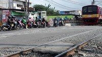 Meski kereta semakin dekat, pemotor nampak tidak takut tersambar.