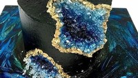 Nah cake hitam yang satu ini temanya galaksi. Selain warna hitam misterius, cake ini juga menghadirkan serpihan batu warna biru yang terbuat dari gula. Foto: Istimewa