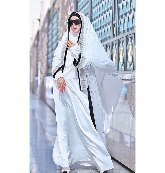 Bukan Syahrini namanya jika memakai busana yang biasa saja, termasuk saat memakai hijab. Kala menunaikan ibadah umrah ia tetap tampil megah. Busana set syari yang ia pilih tetap bernuansa bling-bing. Dok. Instagram.