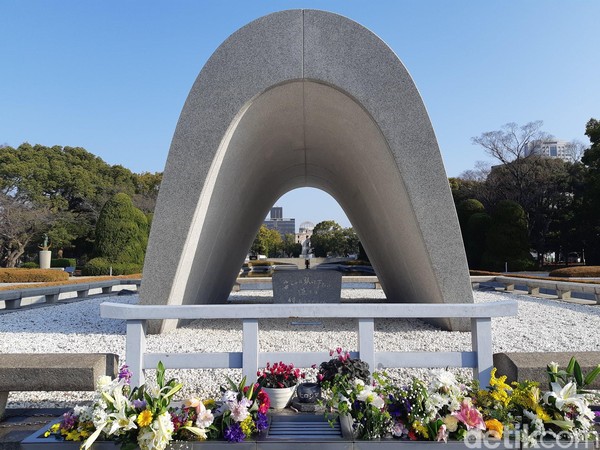 Bagian tengah monumen dibuat bolong dan langsung menghadap ke A-bomb Dome. Bunga dan kata-kata perdamaian terpampang manis di depan monumen ini. (Bonauli/detikTravel) Bagian tengah monumen dibuat bolong dan langsung menghadap ke A-bomb Dome. Bunga dan kata-kata perdamaian terpampang manis di depan monumen ini. (Bonauli/detikTravel)