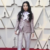 Tampilan maskulin menjadi pilihan Awkwafina. Tubuhnya dibungkus setelan metalik berkilauan dari DSquared2 yang dilengkapi dasi bergaya pussy bow bervolume. Foto: Getty Images