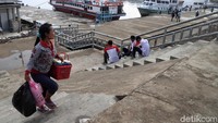Sejumlah warga melintasi tanggul Kali Adem, Maura Angke, Jakarta Utara, Senin (25/2/2019).