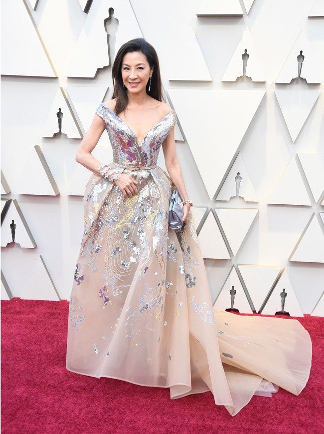 Michelle Yeoh tak kalah glamornya dengan gaun bersiluet ballgown dari Elie Saab. Gaun berbelahan dada rendah itu dihiasi motif abstrak yang meninggalkan kesan kontemporer pada penampilannya. Foto: Getty Images