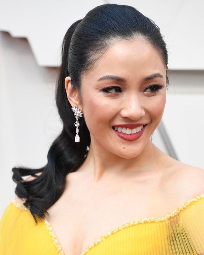 Bintang Crazy Rich Asians Constance Wu datang dengan dress kuning yang cerah. Ia tampil dengan lipstik berry untuk melengkapi gaun kuningnya. Foto: Getty Images