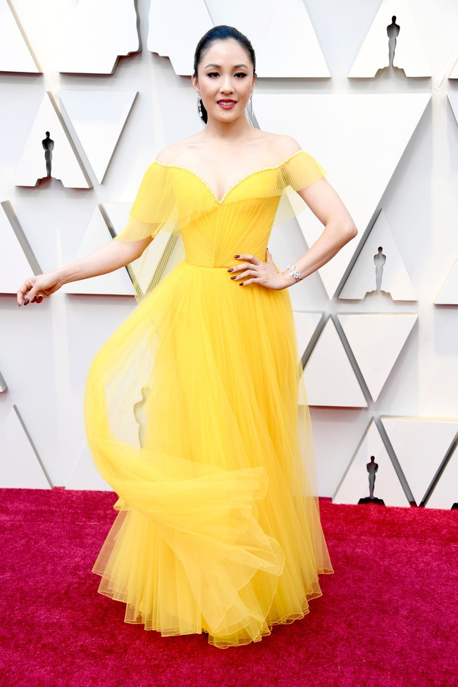 Constance Wu anggun dalam balutan gaun strapless kuning dari Versace yang memamerkan bahu indahnya. Foto: Getty Images