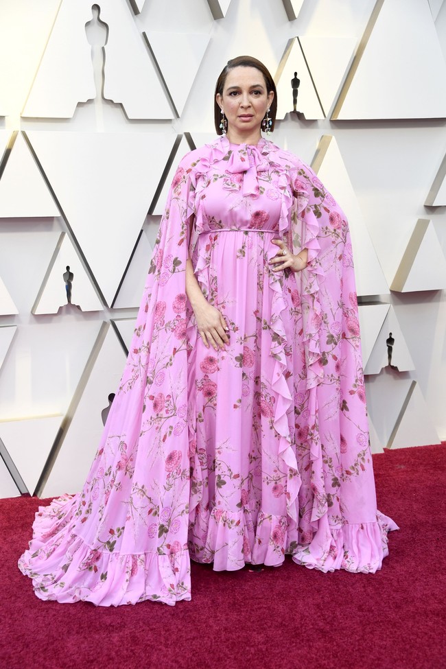 Gaun pink Maya Rudolph memiliki aksen ruffle besar yang membuat ia tenggelam dalam gaunnya. Belum lagi motif floral yang heboh mengesankan Maya memakai gorden atau sprei sebagai gaun. Foto: Frazer Harrison/Getty Images