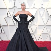 Lady Gaga hadir dalam balutan gaun hitam Alexander McQueen dengan rok yang megar dan pinggul yang melebar. Tidak ketinggalan sarung tangan kulit berwarna hitam yang membungkus hampir semua bagian lengannya. Gayanya kian sempurna berkat kalung berhiaskan batu berlian kuning senilai 128 karat dari Tiffany & Co. dengan harga US$ 30 juta atau sekitar Rp 420 miliar! Foto: Getty Images