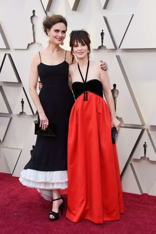 Zooey Deschanel seolah memakai gaun jadul dengan aksen tali di leher dan paduan kontras antara hitam dan merah. Foto: Frazer Harrison/Getty Images