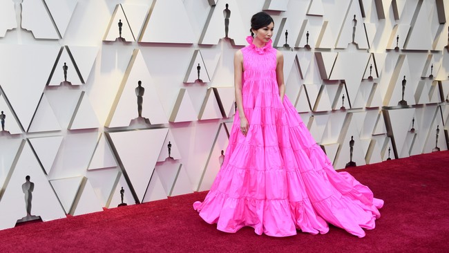 Gemma Chan memilih gaun bervolume dari Valentino yang dilengkapi kantong. Warna pink yang menyala sukses menjadikan Gemma pusat perhatian. Foto: Getty Images