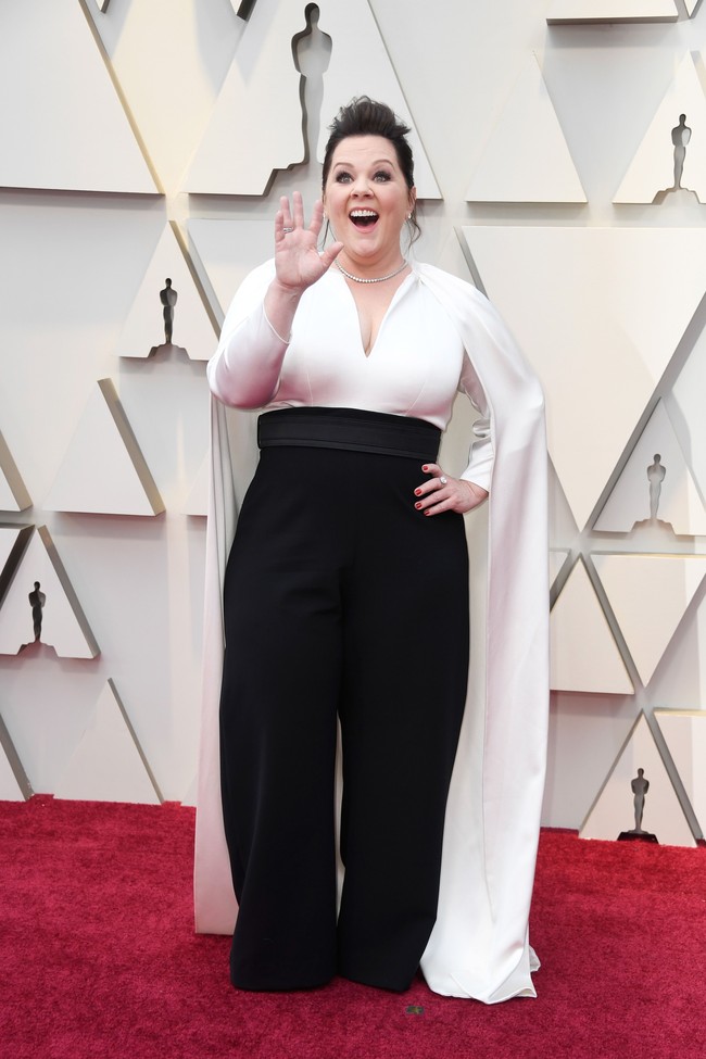 Alih-alih gaun, Melissa McCarthy memilih tampilan dengan celana panjang dari Brandon Maxwell. Busana tersebut dilengkapi sayap yang memperkuat karakter tangguh aktris dan komedian tersebut. Foto: Getty Images