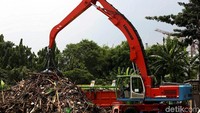 Sebuah alat berat nampak membersihkan sampah yang menumpuk di Pintu Air Manggarai.