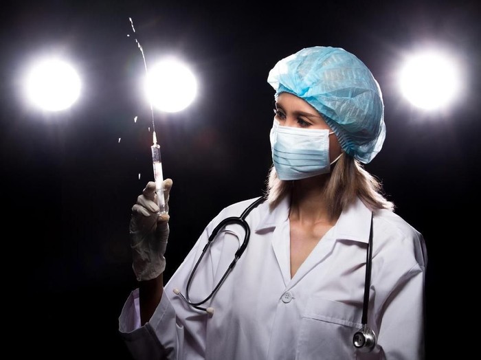 ilustrasi suntikan Asian Beautiful Doctor Nurse woman in uniform with stethoscope, rubber gloves, mask check syringe injection, portrait , studio lighting dark background four back light flare silhouette copy space