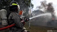 Aksi petugas memadamkan api dari kapal yang terbakar.