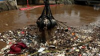 Sampah yang menggenang di Pintu Air Manggarai, Jakarta, mulai dibersihkan, Selasa (26/2/2019).