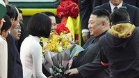 Kim Jong Un menerima karangan bunga sesaat setelah tiba di Stasiun Dong Dang, yang berada di perbatasan antara Vietnam dengan China. Minoru Iwasaki/Kyodo via AP Photo.