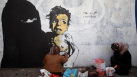 Ekspresi seorang anak yang tergambar dalam mural terlihat sangat ketakutan dengan kondisi badan kurus tanpa busana. REUTERS/Mohamed al-Sayaghi.