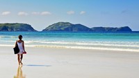 Seorang turis tampak berjalan di pantai Prainhas do Pontal do Atalaia Brasil (iStock)