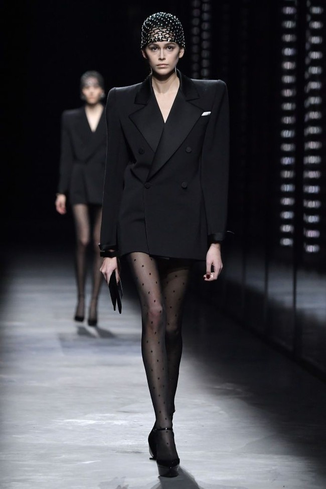 Untuk bawahan, blazer tersebut hanya dipadukan dengan detail polkadot sehingga mempertegas aura seksi sang model. Gaya Kaia lalu disempurnakan dengan headpiece dan clutch tipis berwarna senada, berikut platform heels yang menopang kaki jenjangnya. (Foto: Pascal Le Segretain/Getty Images)