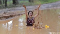 Ada ABG juga yang bergaya layaknya model di kolam renang sambil bermain air. Tapi di sini, dia bermain lumpur. (Robby Ari Sanjaya-ist)