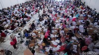 Para relawan melakukan pelipatan dengan duduk lesehan hanya beralaskan kardus.