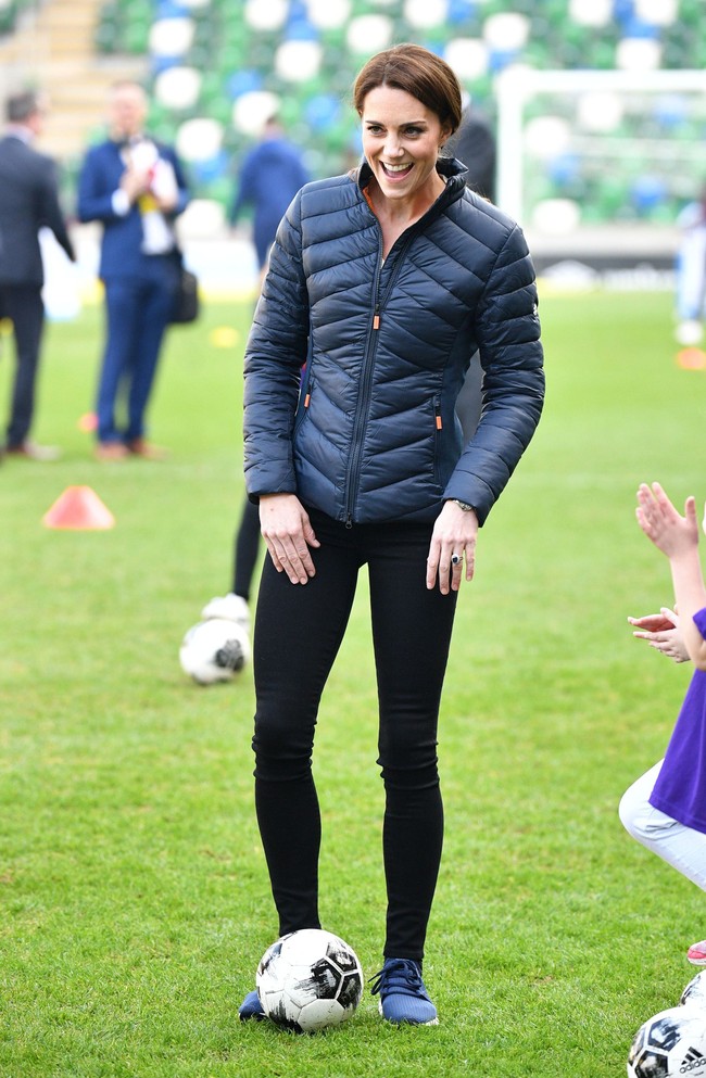 Kate yang tampil dengan jaket tebal, celana olahraga hitam New Balance dan sneakers biru mencoba melancarkan jurusnya menggiring bola di lapangan hijau. Foto: Getty Images