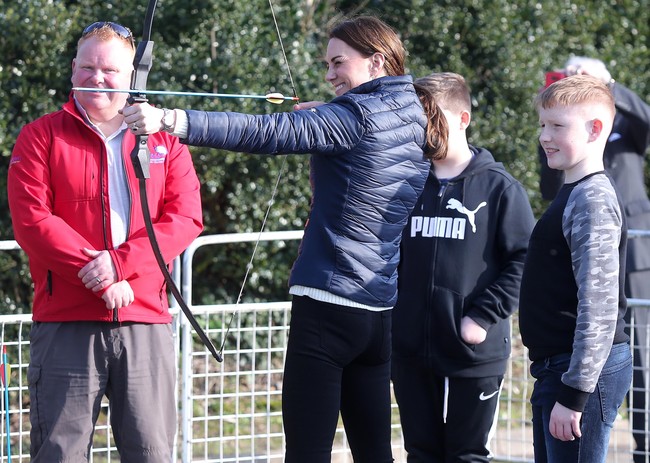 Kegiatan dilanjutkan dengan kunjungan ke perkemahan anak-anak muda Roscor Youth Village. Di situ, Kate menyempatkan diri untuk mencoba memanah. Foto: Getty Images