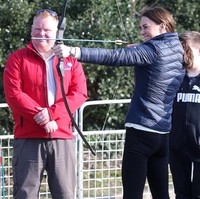 Kegiatan dilanjutkan dengan kunjungan ke perkemahan anak-anak muda Roscor Youth Village. Di situ, Kate menyempatkan diri untuk mencoba memanah. Foto: Getty Images