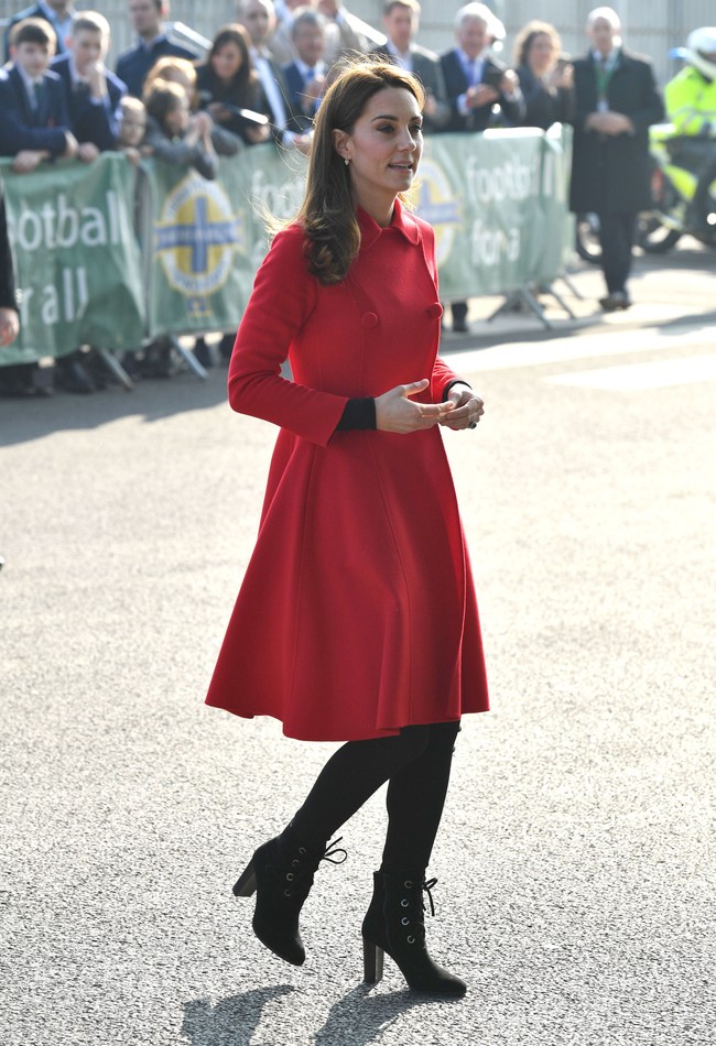 Saat tiba di Belfast, Kate memesona dalam balutan mantel merah berpotongan feminin dari Carolina Herrera. Mantel bernilai Rp 22 juta tersebut dipadukan dengan ankle boots hitam bertali dari label favorit Kate, LK Bennett, seharga Rp 3,7 juta. Foto: Getty Images