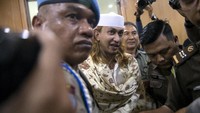 Habib Bahar tiba di ruang sidang PN Bandung dengan mengenakan gamis dan peci putih serta dibalut dengan pashmina berwarna senada. Ia nampak sesekali tersenyum saat memasuki ruang sidang.