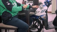 Dalam beberapa postingan, Anton selalu bangga mengenakan atribut ojol mulai dari jaket hingga helm. Ia juga kerap berpose bareng motornya. Foto: Instagram @ojekbule