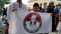 Tampak anak kecil yang memakai peci turut dalam aksi tersebut sambil membawa spanduk bertuliskan dukungan untuk Bahar bin Smith. Foto: Mukhlis Dinillah