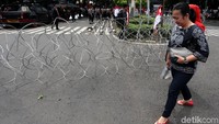 Pihak kepolisian nampak memasang kawat berduri di area sekitar gedung KPU, Jakarta, Jumat (1/3/2019).