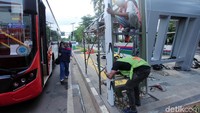 Bus Metrotrans melintas di depan proyek halte di kawasan Senayan.