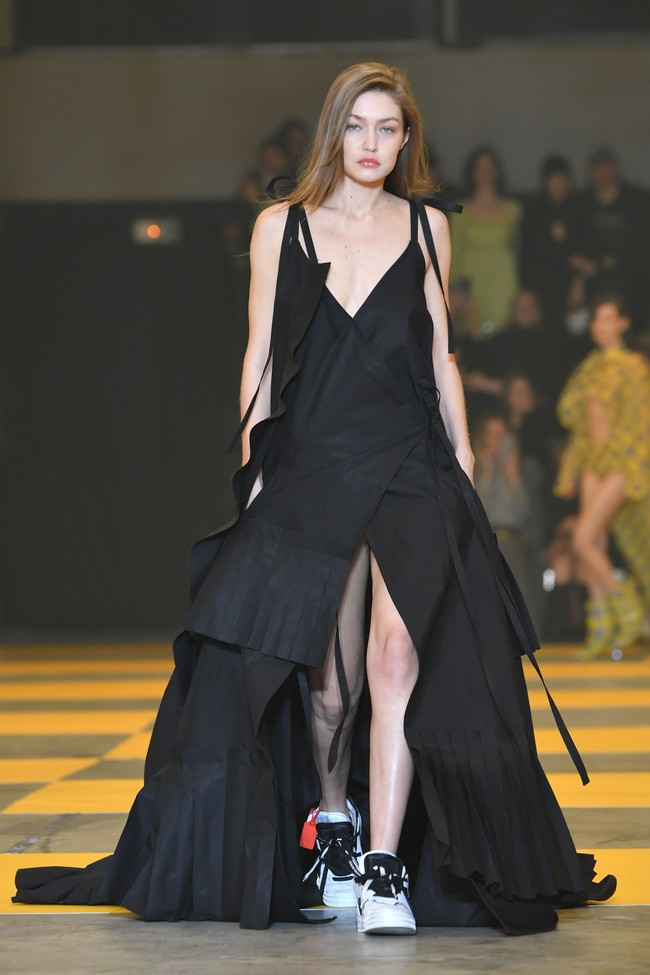 Gigi melenggang dengan gaun hitam bersiluet A yang dihiasi detail temali pada bagian samping. Berbelahan dada rendah dengan belahan tinggi pada bagian rok, gaun tersebut sukses mempertegas keseksian perempuan 23 tahun itu. (Foto: Pascal Le Segretain/Getty Images)