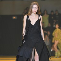 Gigi melenggang dengan gaun hitam bersiluet A yang dihiasi detail temali pada bagian samping. Berbelahan dada rendah dengan belahan tinggi pada bagian rok, gaun tersebut sukses mempertegas keseksian perempuan 23 tahun itu. (Foto: Pascal Le Segretain/Getty Images)