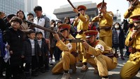 Sejumlah warga mengenakan pakaian militer Jepang dan beraksi seakan-akan hendak menembak warga yang sedang berdemonstrasi menuntut kemerdekaan Korea tepat 100 tahun yang lalu, pada 1 Maret 1919. Chung Sung-Jun/Getty Images.