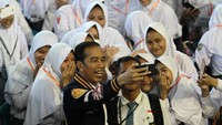 Usai menyerahkan KIP Presiden Jokowi mengajak swafoto dengan sejumlah pelajar yang ada disana. Beginilah keseruannya. Antara Foto/Adiwinata Solihin.