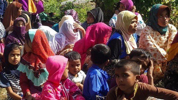 Rohingya refugees, who landed on an isolated northern shore near the Malaysia-Thai border, huddle in a group in Kangar on March 1, 2019, following their detention by Malaysian immigration authorities. - Thirty-four Rohingya landed on an isolated beach in Malaysia on March 1, police said, the first group of the Muslim minority caught arriving in the country by sea for almost a year. (Photo by ISMAEL KAMALDIN / AFP)