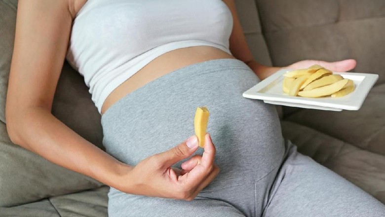 Ilustrasi ibu hamil makan mangga muda/ Foto: iStock Ilustrasi ibu hamil makan mangga muda/ Foto: iStock