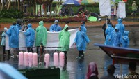 Meski diguyur hujan para warga terlihat mengenakan jas hujan untuk melindungi tubuh.