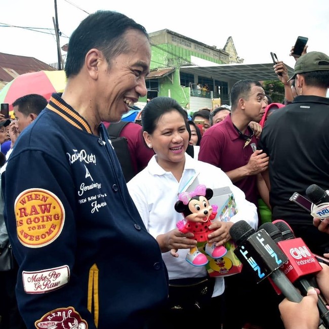 Baru-baru ini, Presiden Joko Widodo atau Jokowi melakukan kunjungan kerja ke sejumlah daerah di Sulawesi. Dalam kesempatan tersebut, Jokowi terlihat beberapa kali memakai sebauh jaket biru dongker bergaya varsity. Jaket varsity sempat sangat populer saat film Dilan 1990 dirilis. Jaket varsity ini dipakai oleh Milea. Foto: Dok. Instagram