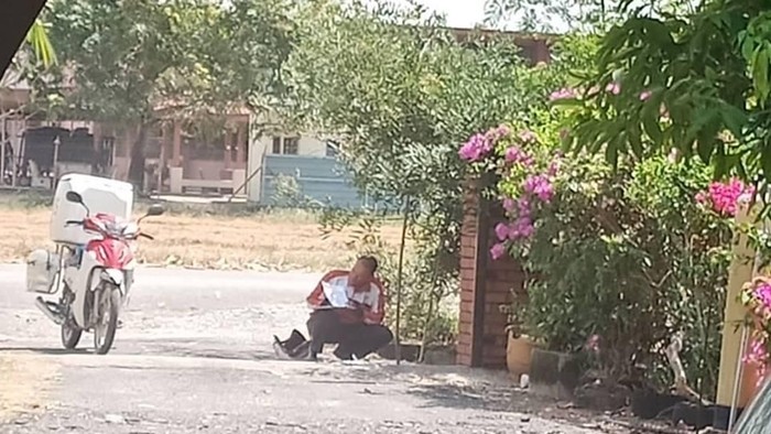 Potret tukang pos berteduh viral. Foto: Facebook Potret tukang pos berteduh viral. Foto: Facebook