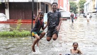 Sejumlah anak bermain di genangan banjir di kawasan ruko tekstil ITC Mangga Dua, Jakarta Barat, Selasa (5/3).