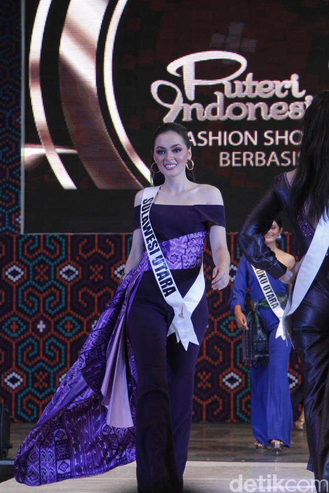 Jolene Marie dari Sulawesi Utara tampil dramatis dengan jumpsuit ungu off the shoulder, yang diberi ornamen train berterbangan ketika ia melangkah. Foto: Mohammad Abduh/Wolipop